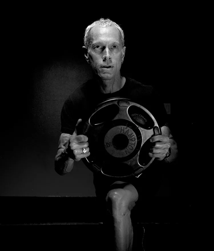 Rick Scott holding a weight plate, black and white
